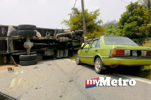 KEADAAN lori yang terbalik setelah terbabit dalam kemalangan dengan kereta. FOTO ihsan pembaca