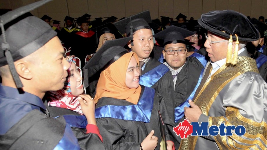 MAHDZIR (kanan) beramah mesra bersama graduan di Majlis Konvokesyen. FOTO Shahrul Hafiz Zam