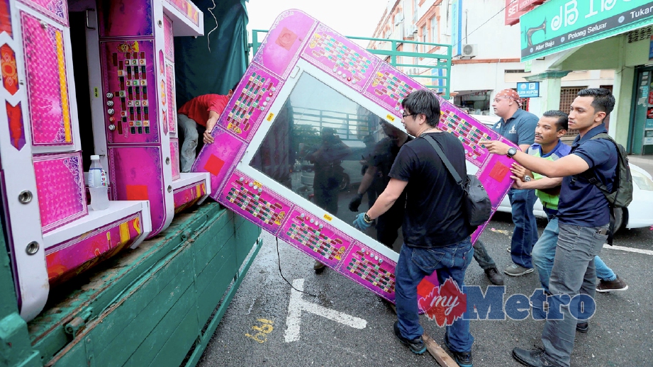 ANGGOTA polis memasukkan mesin judi yang dirampas di premis perniagaan di Pekan Simpang Kuala ke dalam lori untuk dibawa ke Ibu Pejabat Polis Daerah Kota Setar. FOTO Amran Hamid