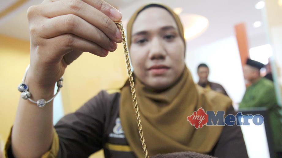 PENOLONG Pengurus Ar Rahnu Tekun Cawangan Alor Setar, Nurul Hashikin Mohamad menunjukkan emas yang dicagar pelanggan. FOTO Sharul Hafiz Zam