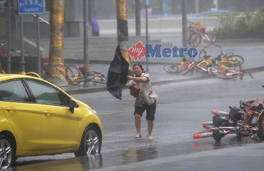 SEORANG wanita memegang payung ketika Taufan Mangkhut mula melanda Shenzhen, China. FOTO/REUTERS 