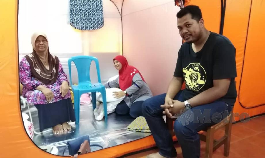 ASIAH (kiri) bersama ahli keluarga terpaksa berkampung sementara di PPS Sekolah Kebangsaan (SK) Ijok berikutan banjir melanda Ijok sejak 15 November lalu. FOTO ihsan Angkatan Pertahanan Awam Malaysia (APM). 