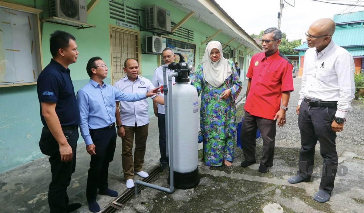 LEE (dua dari kiri) memberi penerangan mengenai penapis air keluaran Waterco ketika Program TKHM bersama Waterco  di Masjid Kampung Sungai Chinchin. FOTO Amirudin Sahib