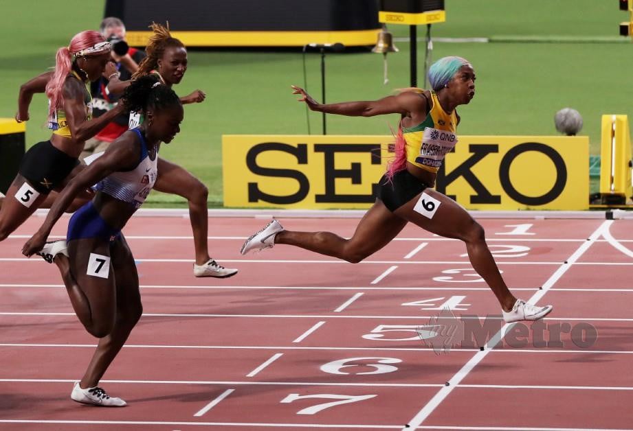 Shelly-Ann (kanan) melepasi garisan penamat acara 100 meter wanita di Kejohanan Olahraga Dunia di Doha. FOTO Reuters