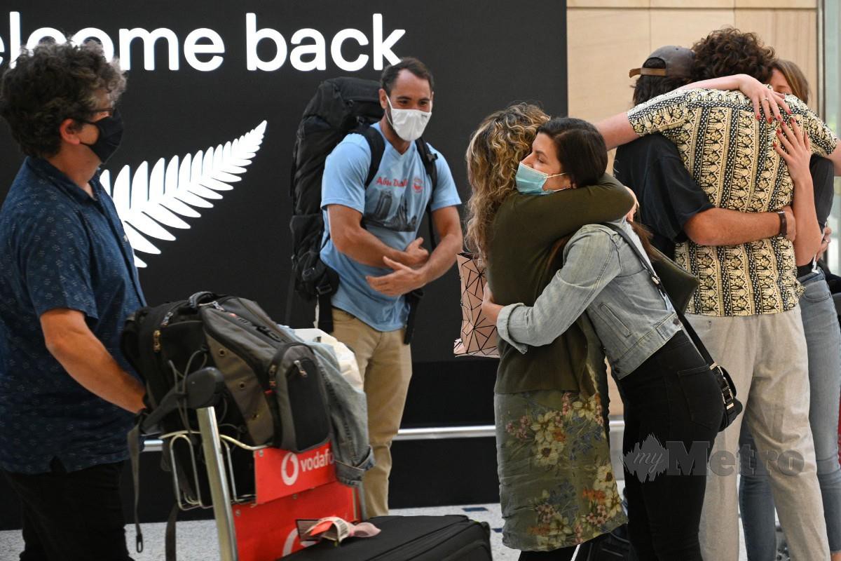 AHLI keluarga saling berpelukan ketika tiba di New Zealand. FOTO AFP