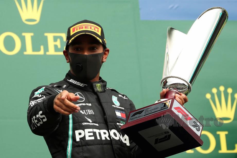 Hamilton bersama trofi yang dimenangi di GP Belgium. FOTO AFP