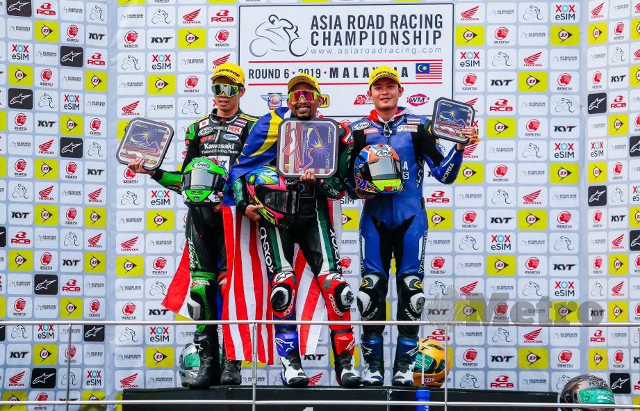 AZLAN Shah (tengah) muncul juara dalam Pusingan Enam Perlumbaan Satu ASB1000 bergambar selepas penyampaian hadiah Kejuaraan Motosikal Asia (ARRC) 2019 di Litar Antarabangsa Sepang (SIC).