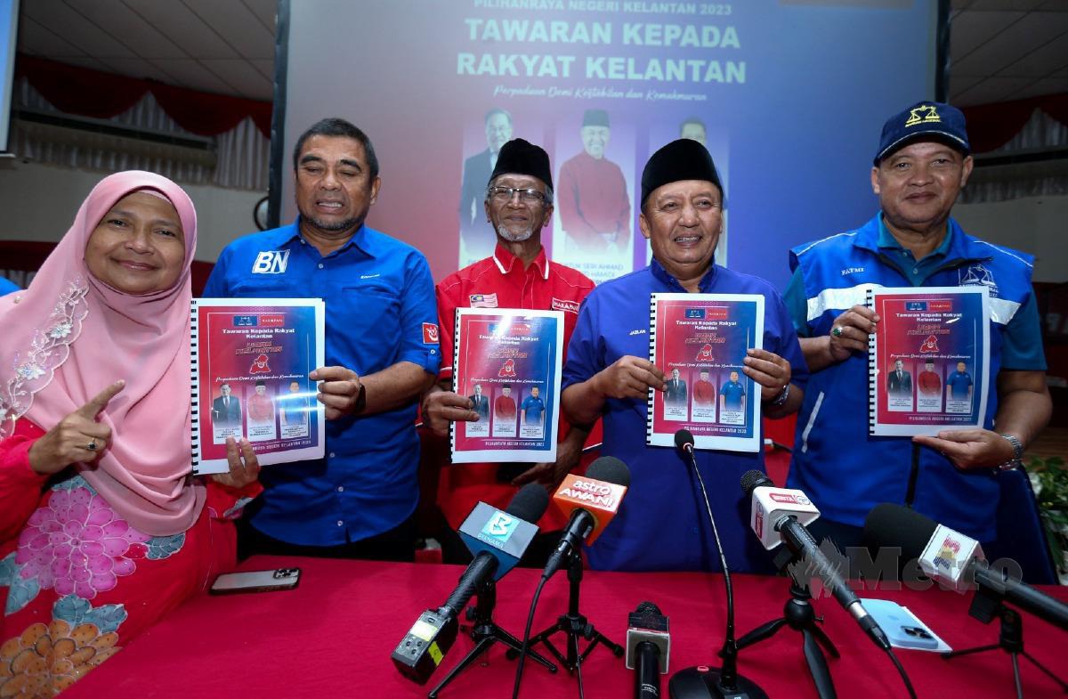 AHMAD Jazlan (dua kanan) menunjukkan manifesto BN-PH di Pejabat Umno Kelantan. FOTO Nik Abdullah Nik Omar