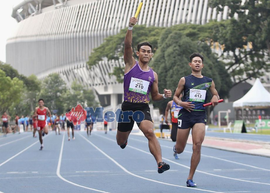 MUHAMMAD Aiedel Sa’adon (kiri) selaku pelari terakhir acara 4x100m lelaki meraikan kemenangan emas pada Kejohanan Olahraga Sukan Sekolah-Sekolah ASEAN di MSN Bukit Jalil. Foto NSTP/NUR ADIBAH AHMAD IZAM