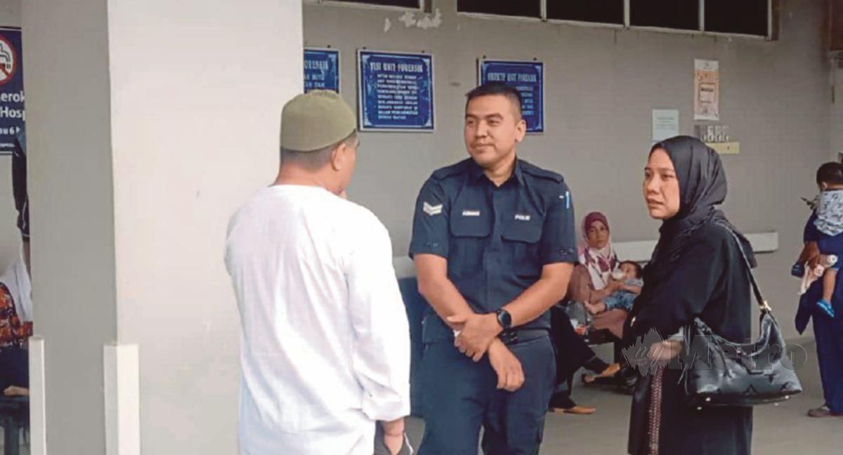 Ketua Polis Daerah Lipis, Superintenden Azli Mohd Noor (baju putih) turut berada di Unit Forensik, Hospital Lipis bersama suami arwah, Mohd Azman Mat Yaacob  (beruniform). FOTO Amir Hamzah Nordin .