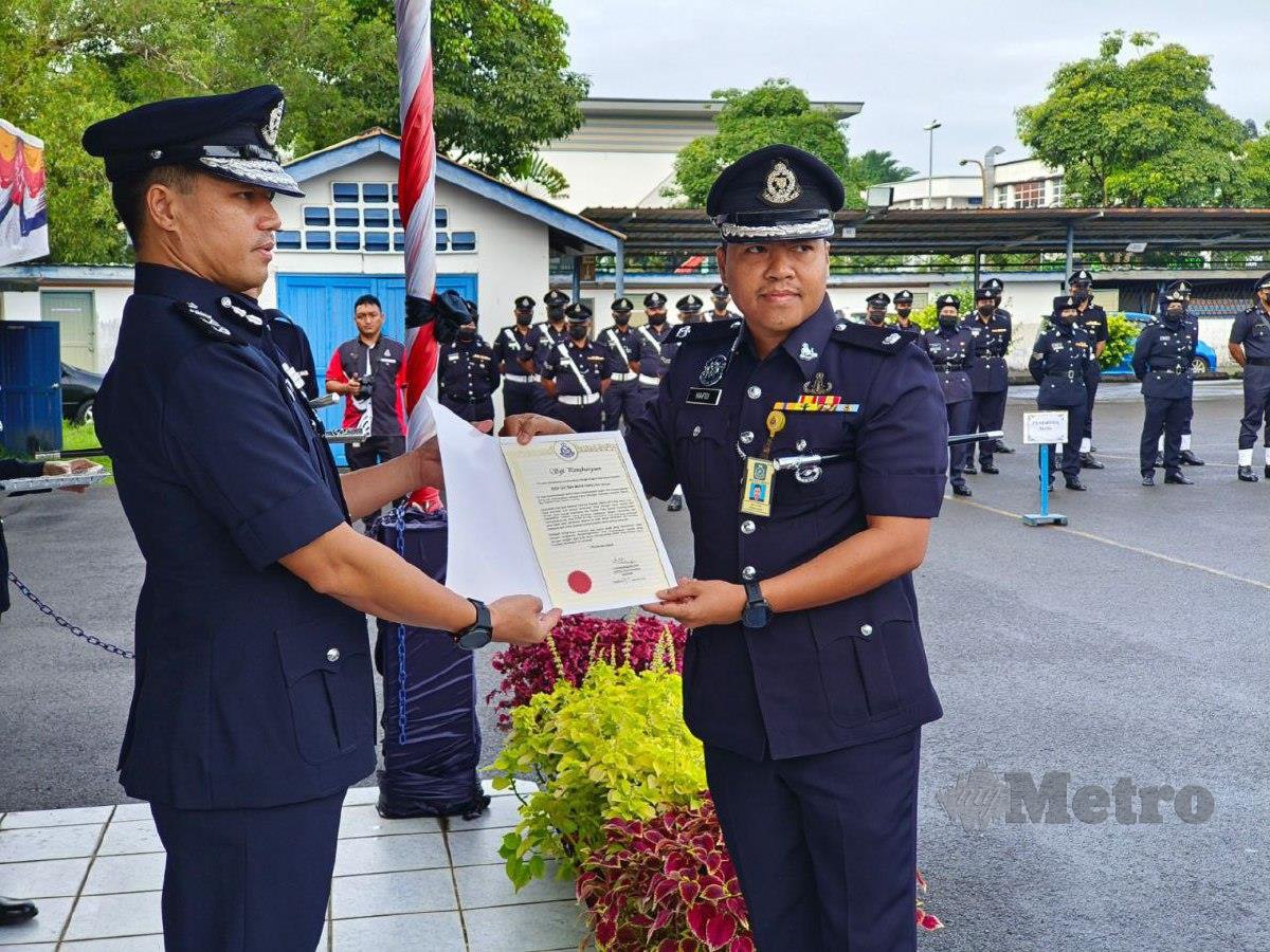 AHSMON (kiri) menyampaikan sijil penghargaan kepada pegawai pada perbarisan bulanan IPD Kuching hari ini. FOTO Mohd Roji Kawi