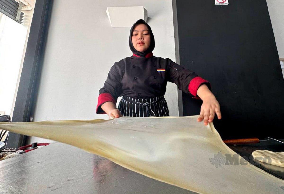 Atirah Asmaa menebar roti canai ketika ditemui di sebuah kopitiam yang diusahakan di bangunan Hotel H Elite, Tunjong, di sini. FOTO NIK ABDULLAH NIK OMAR