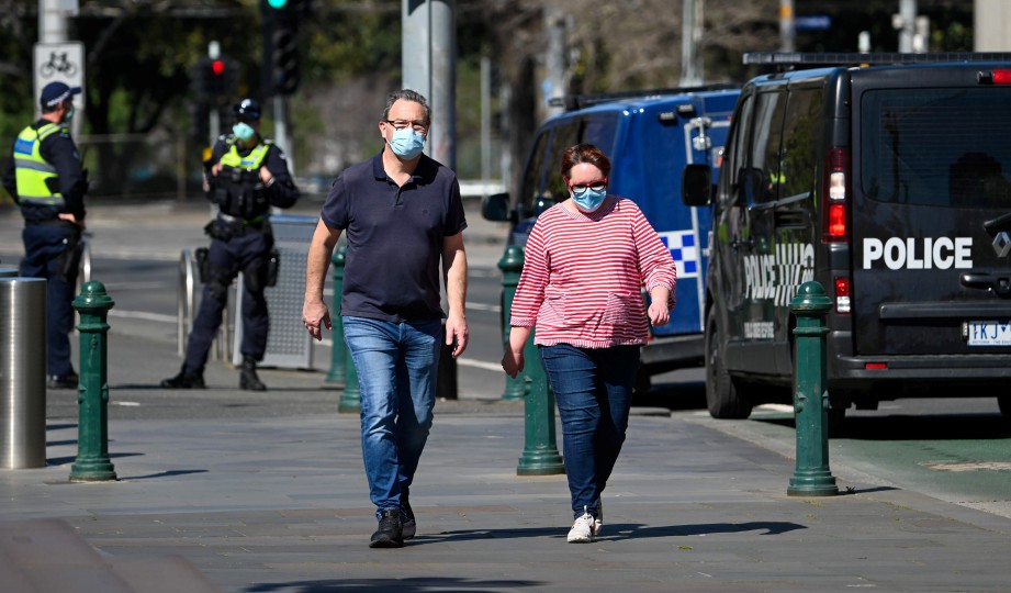 ORANG awam memakai pelitup muka ketika berjalan di Melbourne. FOTO AFP 