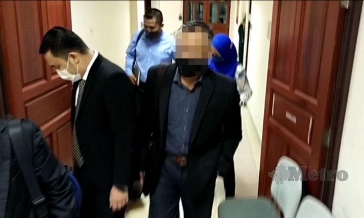 AZMAN (kanan) ketika diiring masuk ke bilik perbicaraan Mahkamah Sesyen Ipoh, atas pertuduhan terbabit aktiviti pengubahan wang haram berjumlah RM114,000. FOTO MUHAMMAD ZULSYAMINI SUFIAN SURI