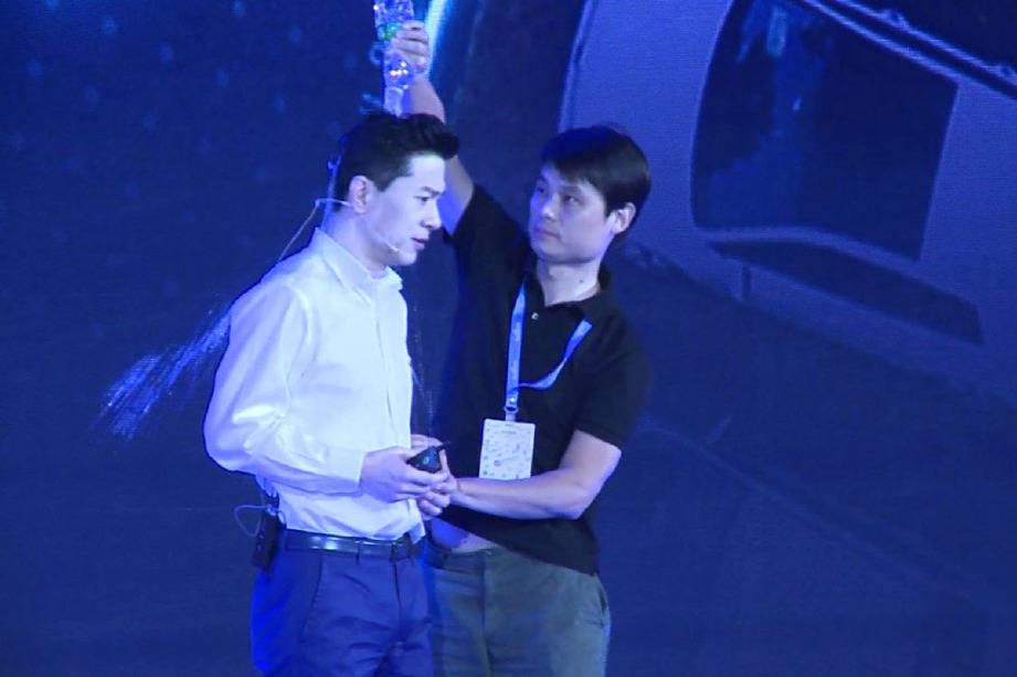 CHENG bertindak menuang sebotol air ke atas kepala Li ketika dia sedang memberi penyampaian pada acara tahunan Baidu. FOTO SCMP