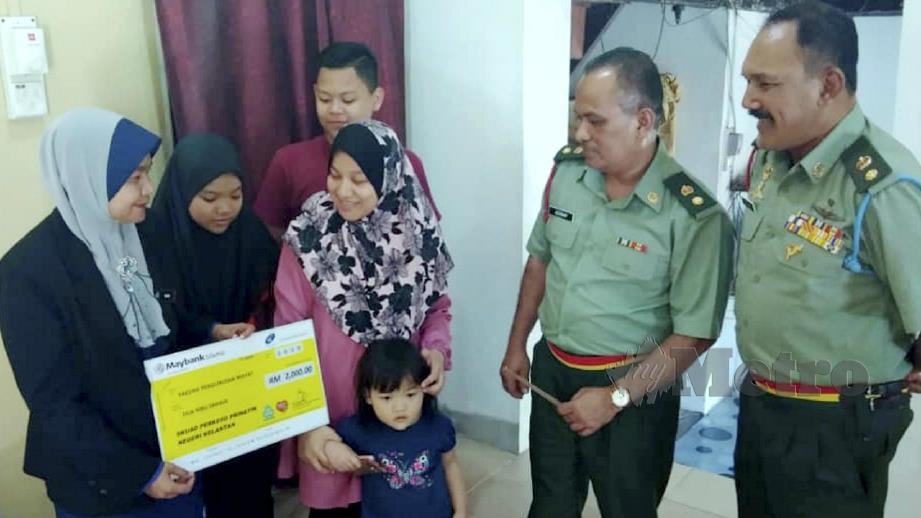 NOR Sayuti (tiga dari kiri) bersama tiga anaknya menerima pencen Penakat PERKESO disampaikan Pengarah PERKESO Kelantan, Nora Yaccob (kiri). FOTO Hazira Ahmad Zaidi.