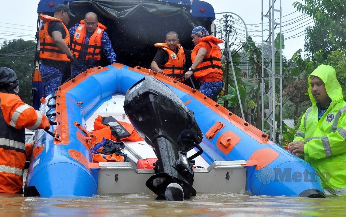 Anggota Angkatan Pertahanan Awam Malaysia (APM) menurunkan bot untuk menyelamatkan mangsa banjir yang terkandas di Penampang Proper hari ini. FOTO Mohd Adam Arinin