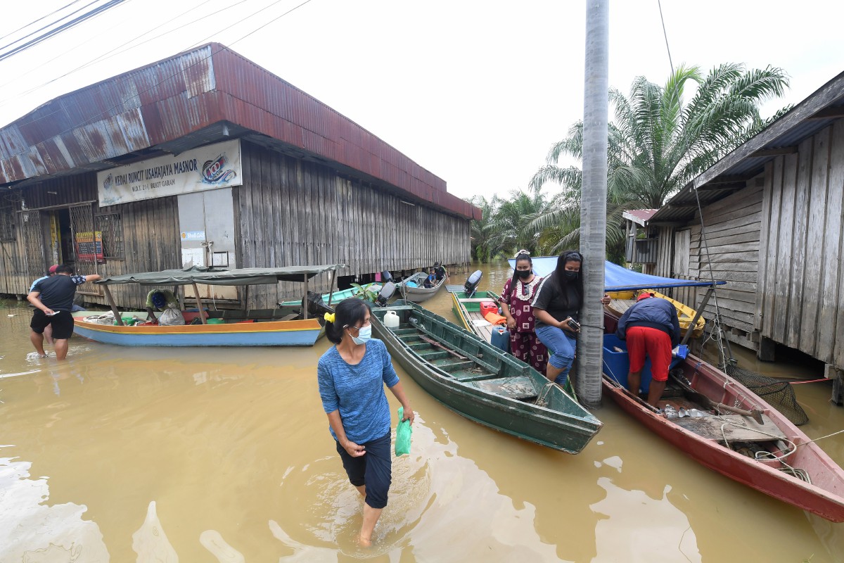 PENDUDUK di Kinabatangan terpaksa menggunakan bot selepas jeti di Pangkalan Bukit Garam ditenggelami air. FOTO Bernama 