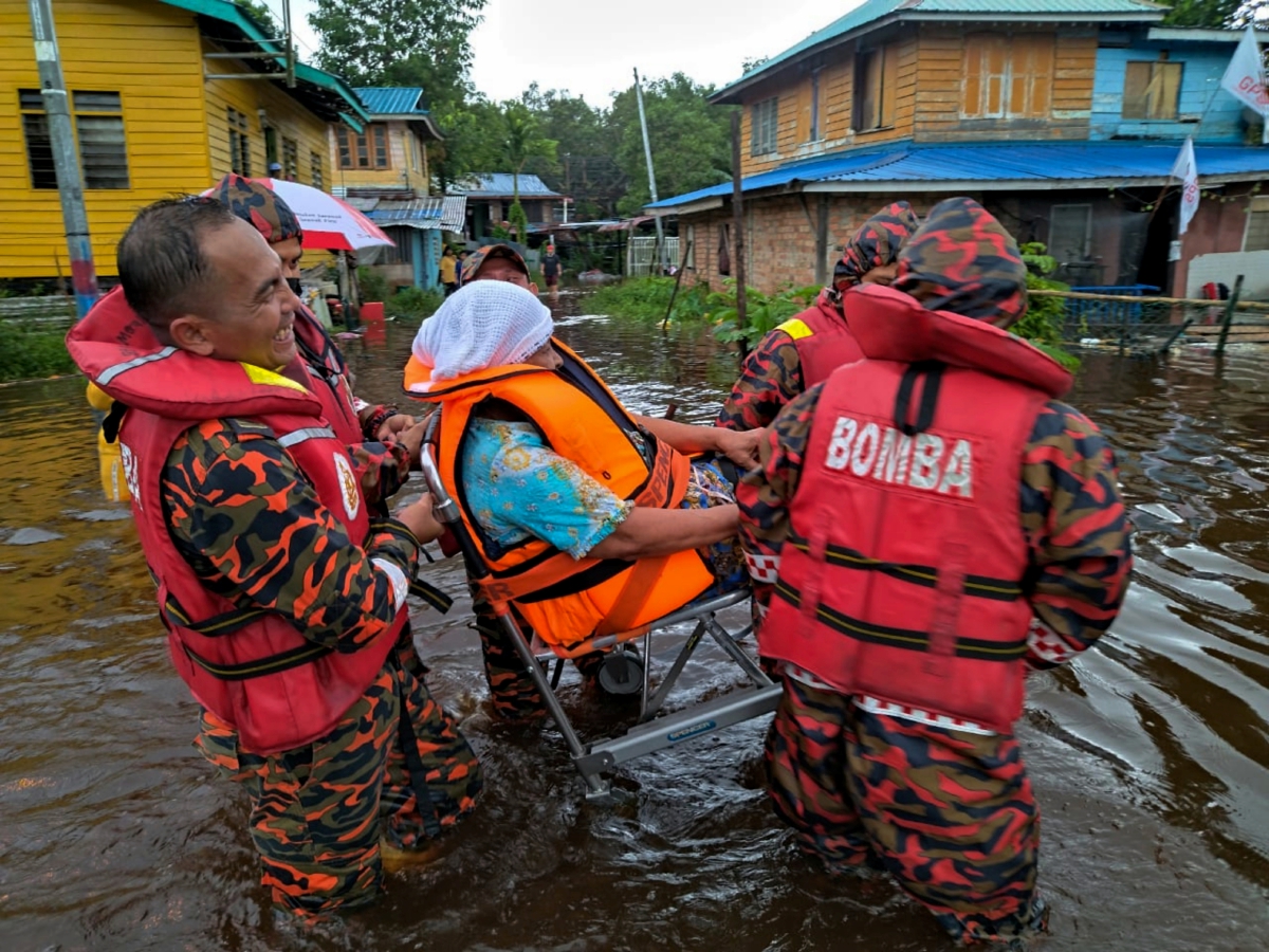 ANGGOTA bomba memindahkan mangsa banjir di Sibu. FOTO Bernama
