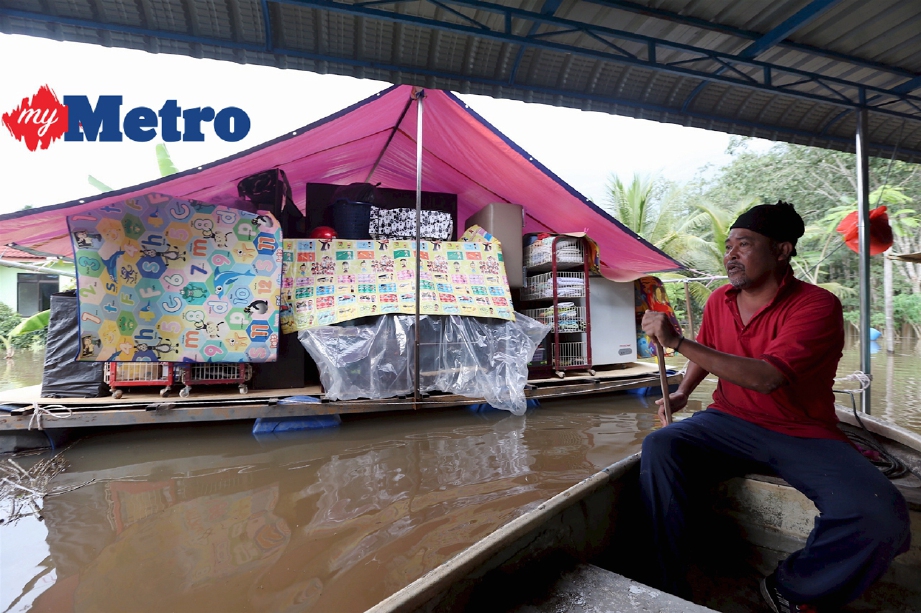 Abdul Manan Joraimi meninjau keadaan rakit yang digunakan untuk meletakkan perkakas rumah supaya tidak ditenggelami air akibat banjir di Kampung Jawa, Lenga, Muar. FOTO Adi Safri