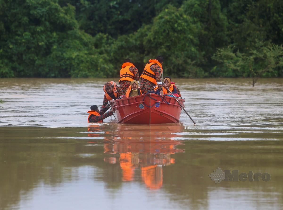 ANGGOTA bomba menyelamatkan mangsa banjir yang terperangkap di Kampung Londah akibat banjir. 