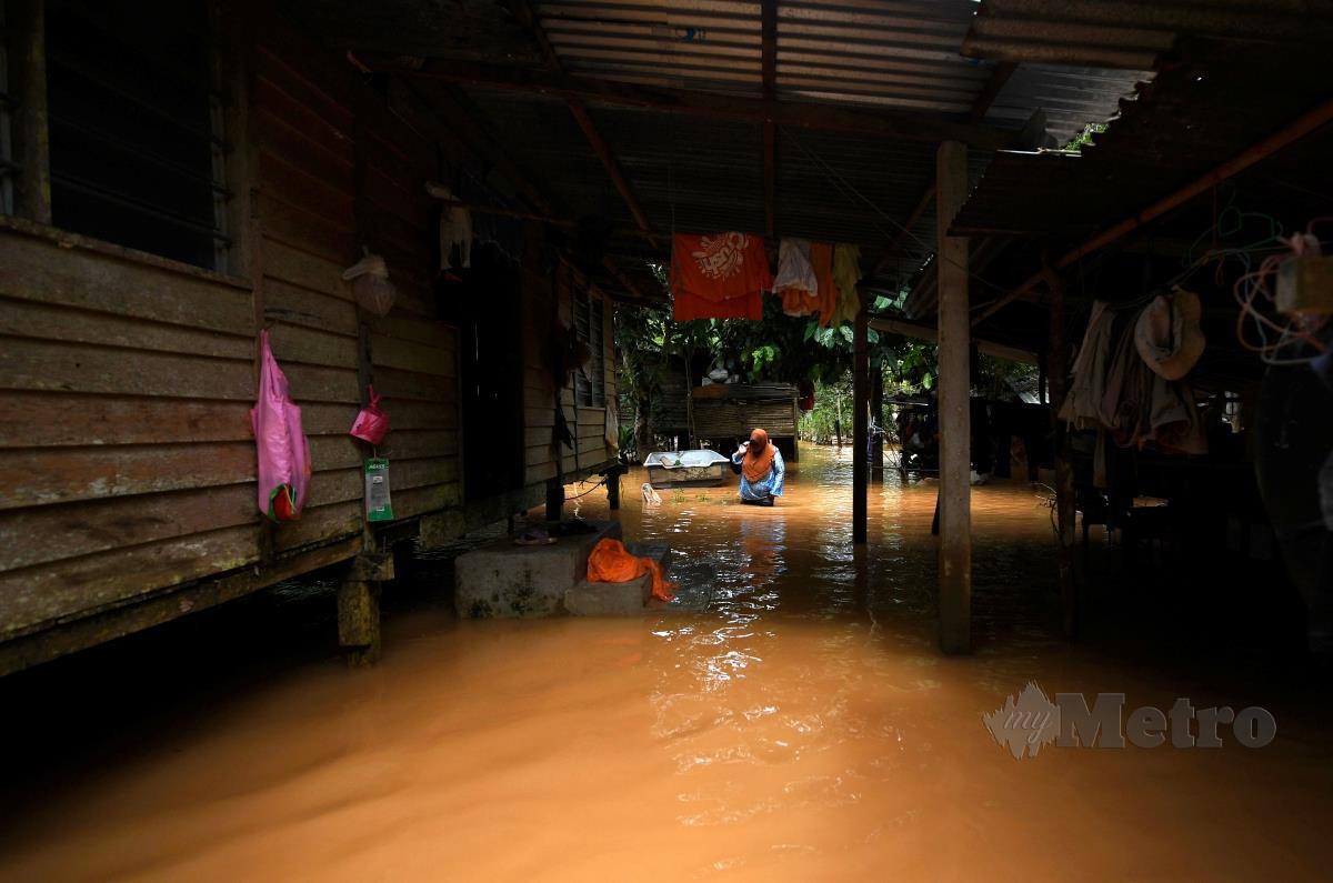 PENDUDUK meredah banjir. FOTO BERNAMA