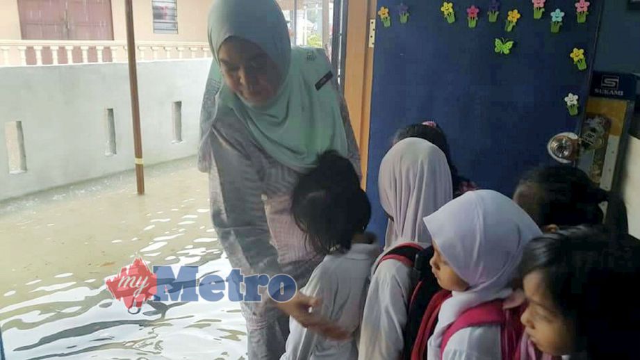 MURID Sekolah Kebangsaan Port Dickson (SKPD) terpaksa pulang awal ke rumah kerana kelas dinaiki air hampir 0.5 meter, semalam. Foto STR/MOHD KHIDIR ZAKARIA