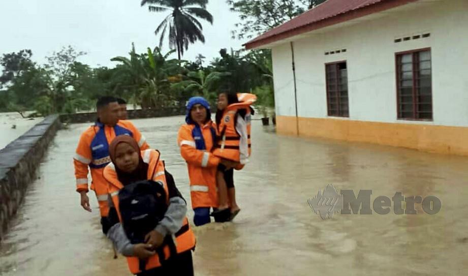 ANGGOTA Angkatan Pertahanan Awam menyelamatkan mangsa banjir di Pusat Penempatan Rakyat Termiskin (PPRT) Jalan Sawi, Kluang. FOTO Adnan Ibrahim