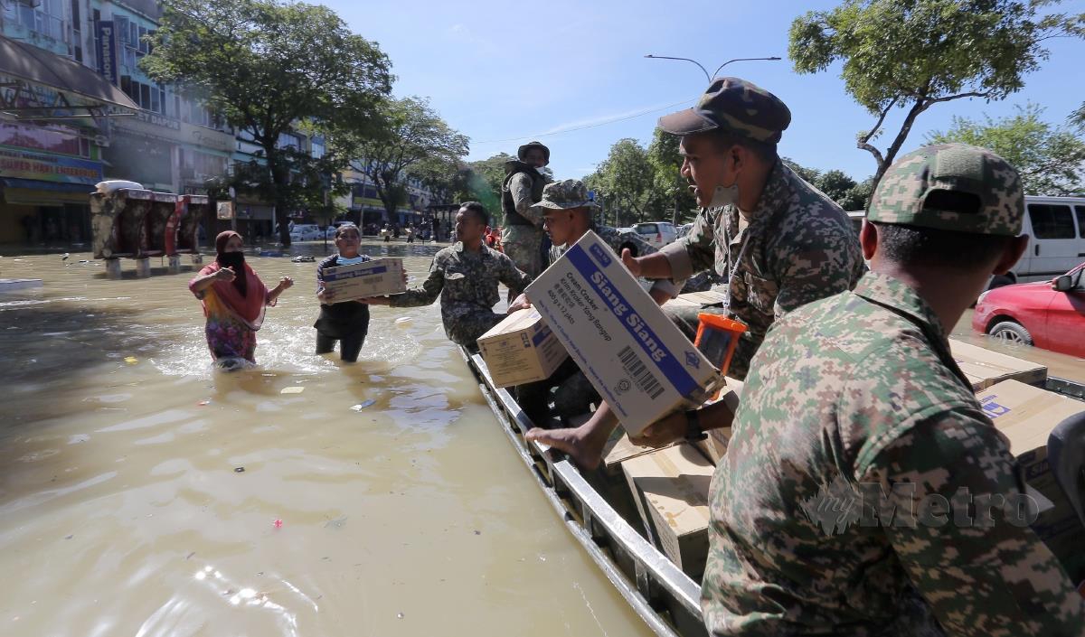 ANGGOTA Angkatan Tentera Malaysia (ATM) mengagihkan bantuan kepada mangsa banjir Taman Sri Muda, Shah Alam. FOTO OSMAN ADNAN 