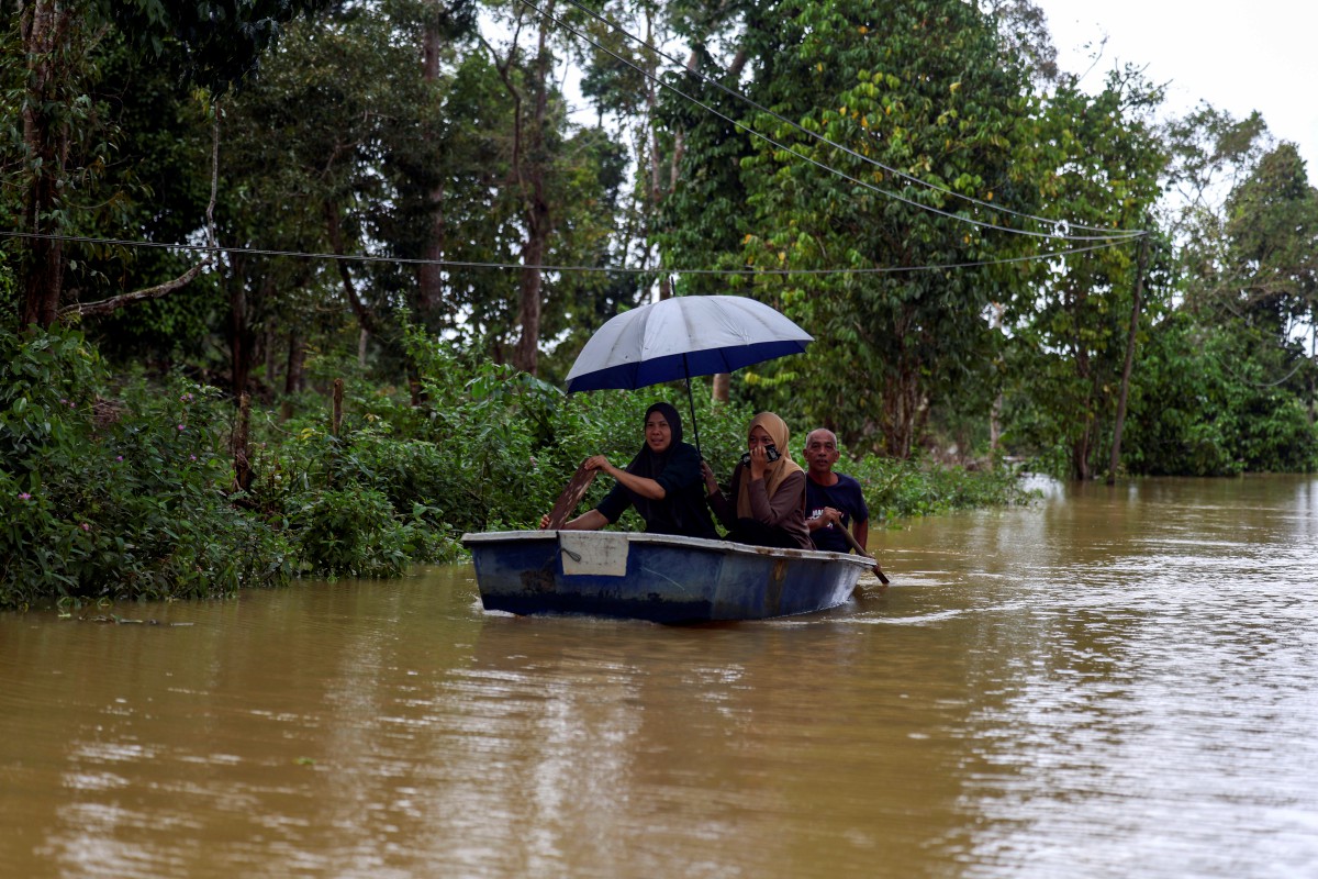 PENDUDUK kampung menggunakan bot untuk keluar ke jalan utama yang masih terputus akibat banjir di Kampung Delong, Dungun. FOTO BERNAMA 