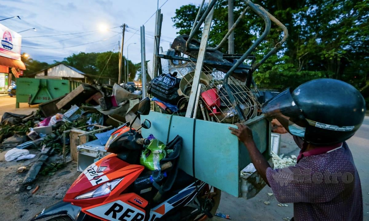 PENDUDUK mengumpul perabot yang rosak akibat banjir selepas tragedi kepala air di Gunung Jerai, Yan. FOTO LUQMAN HAKIM ZUBIR 