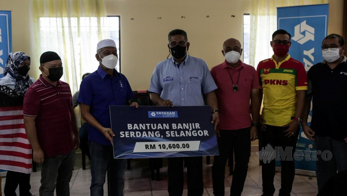 Megat Zulkarnain menyampaikan cek sumbangan RM10,600 kepada Mohamed Satim Diman pada progam bantuan mangsa banjir YBR di Dewan Rukun Tetangga Taman Sri Serdang. FOTO HAZREEN MOHAMAD