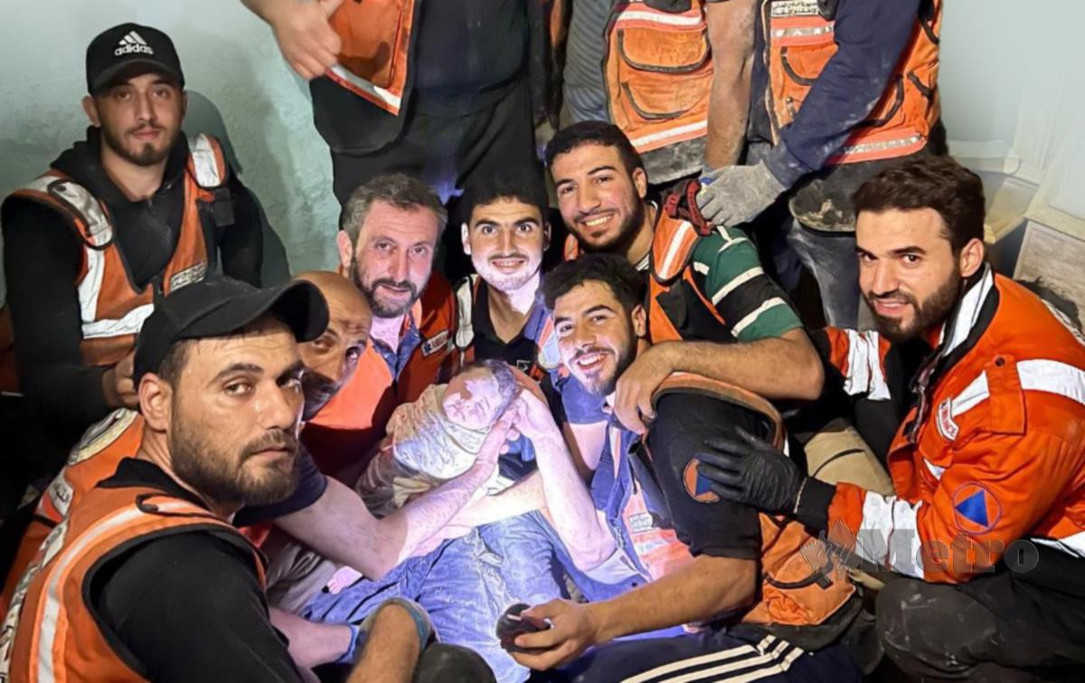 BARISAN anggota penyelamat bersama bayi yang berjaya diselamatkan daripada runtuhan rumahnya di utara Gaza.
