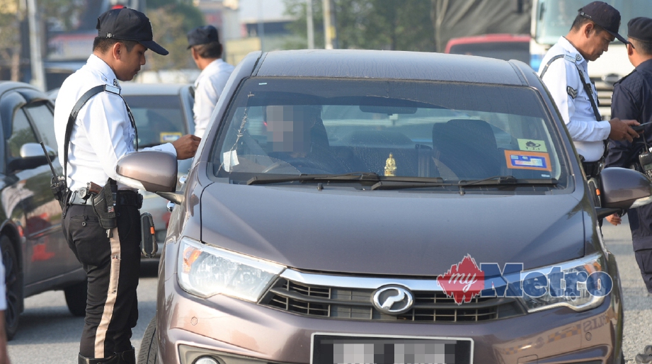 ANGGOTA Polis Trafik Daerah Klang Selatan membuat pemeriksaan terhadap pemandu ketika Ops Selamat 12 sempena Tahun Baru Cina di Jalan Klang Banting, Pandamaran. FOTO Mohd Asri Saifuddin Mamat