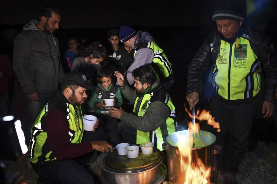 AHMAD Sani mengagihkan sup panas kepada kanak-kanak pelarian. FOTO BERNAMA. 