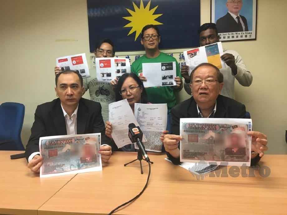 SENG (tengah duduk) bersama Michael (kanan duduk) menunjukkan laporan polis berhubung penipuan jual beli motosikal dalam talian di Pejabat Biro Pengaduan Awam MCA. FOTO NSTP