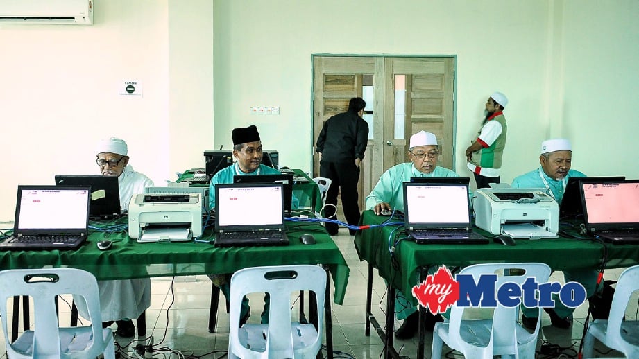 PRESIDEN PAS, Datuk Seri Abdul Hadi Awang (kiri) ketika mengundi menggunakan sistem pengundian Elektronik (E-Undi) untuk pemilihan Ahli Jawatankuasa Pusat pada 29 April lalu. FOTO BernamaADIB HASRI