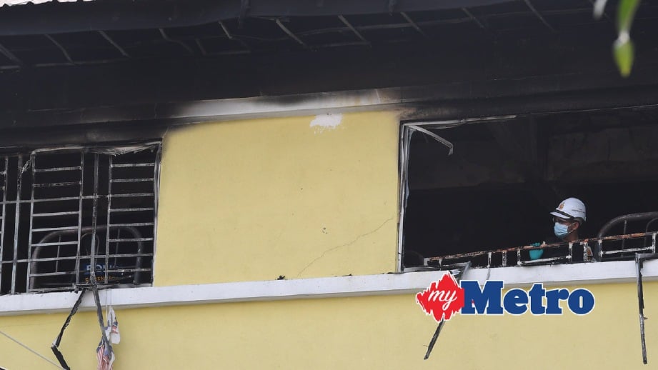 ANGGOTA Bomba dan Penyelamat memantau keadaan tingkat atas yang terbakar di sekolah Darul Quran Ittifaqiyah.  FOTO Bernama