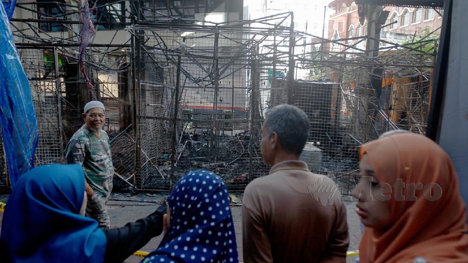 ORANG awam meninjau keadaan bazar tersebut yang terbabit dalam kebakaran. FOTO Bernama