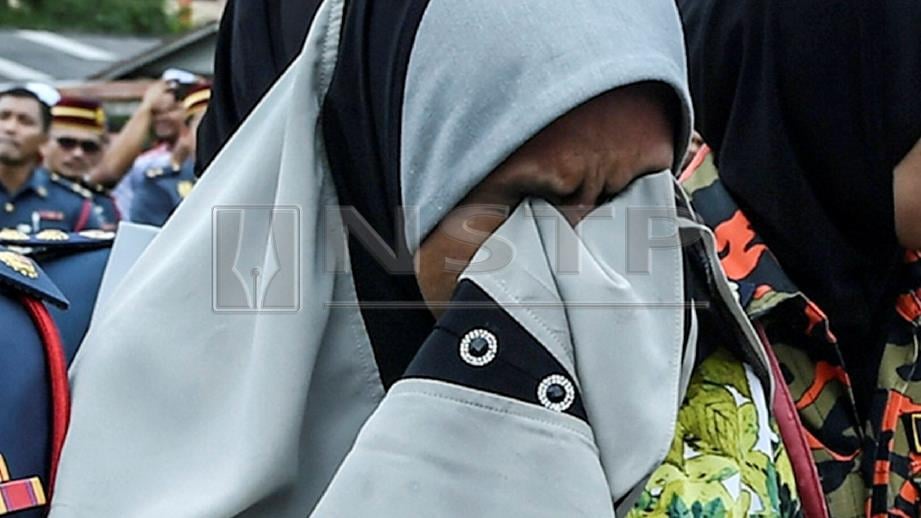 ASMA menahan sebak sebaik jenazah anaknya tiba dengan helikopter di padang SK Tebengau, Kedah, untuk upacara pengebumian, semalam. FOTO Bernama