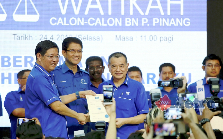 Teng (kiri) menyampaikan watikah pencalonan kepada calon Machang Bubuk, Tan Teik Cheng pada Majlis Penyerahan Watikah Calon-Calon BN Pulau Pinang. FOTO Mikail Ong  