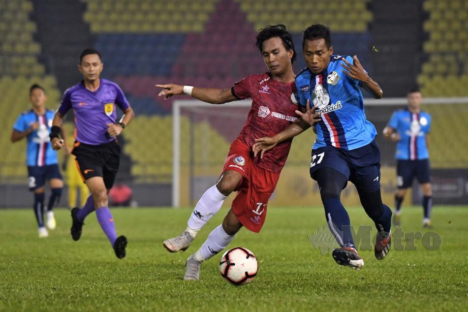 PEMAIN  PDRM,  Muhammad Eskandar Ismail (kanan) mengasak  pemain Sarawak, Nor Azizi Ramlee   di Stadium Hang Jebat.  - FOTO BERNAMA