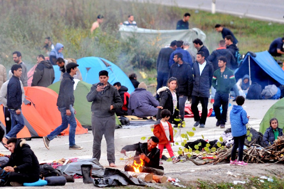 PENDATANG dari Asia berkhemah di atas jalan raya di daerah Maljevac berhampiran sempadan Croatia. FOTO AFP