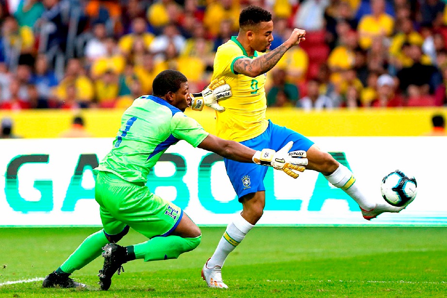 JESUS (kanan) melepasi penjaga gol Luis Lopez ketika aksi persahabatan Brazil menentang Honduras. FOTO AFP