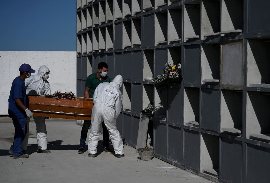 PETUGAS tapak perkuburan memakai peralatan perlindungan untuk mengurus jenazah mangsa mati akibat Covid-19 di Rio de Janeiro, Brazil. FOTO AFP.