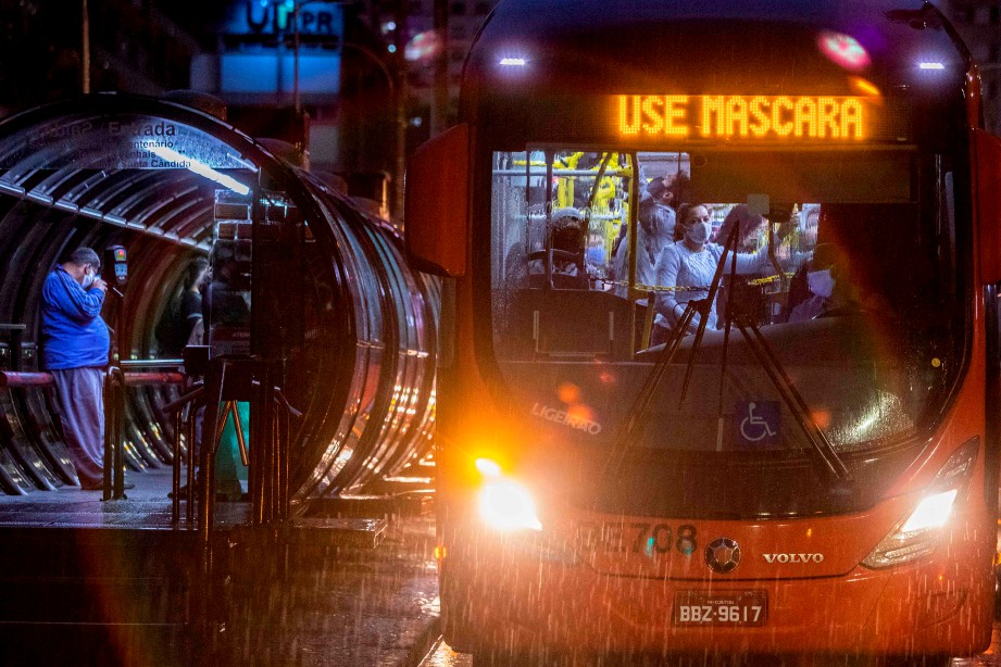 PENGGUNA pengangkutan awam di Curitiba, Brazil memakai pelitup muka. FOTO AFP 