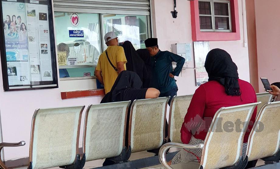 ANGGOTA keluarga berurusan di kaunter Jabatan Forensik, Hospital Melaka untuk menuntut jenazah. FOTO Khairunisah Lokman