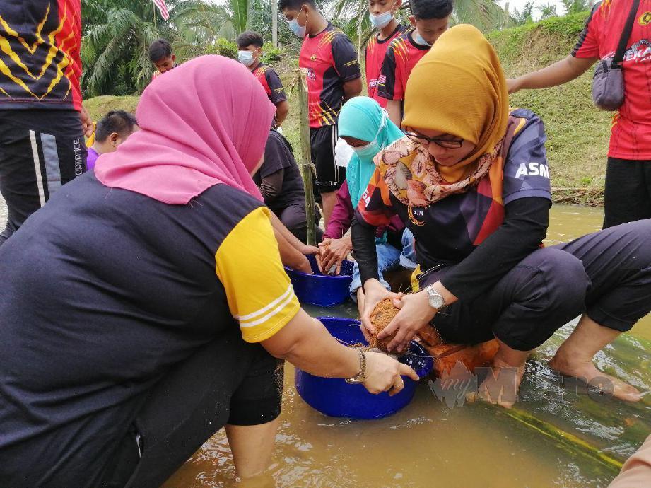 PESERTA pesta air dan sukan rakyat mengukur kelapa didalam sungai pada program yang diadakan di Kampung Datuk Johan. FOTO ABNOR HAMIZAM