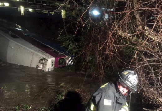 Anggota bomba memeriksa gerabak kereta api yang terjunam ke dalam sungai bagi mencari kemungkinan ada penumpang yang terperangkap. - Foto REUTERS