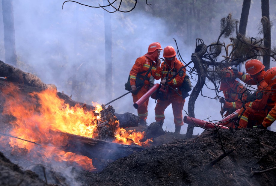BOMBA memadamkan kebakaran hutan berhampiran Liangshan di wilayah Sichuan, China. FOTO Reuters 